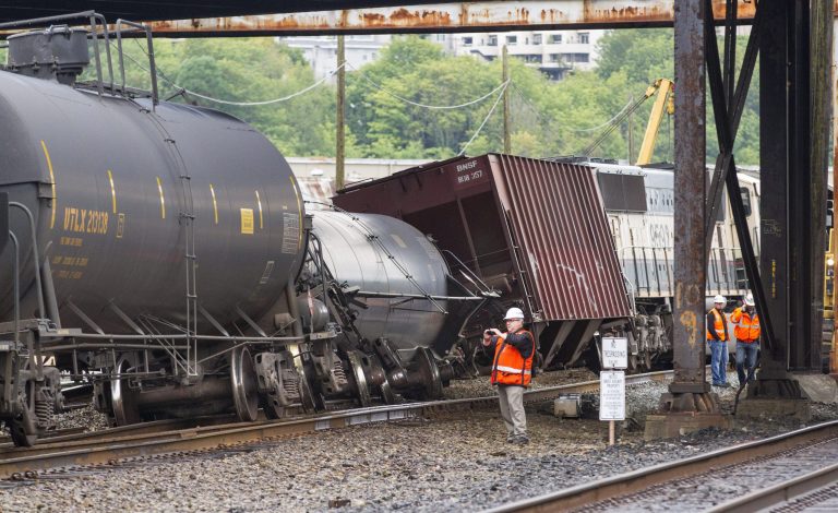 An investigator photographs the scene where a locomotive and cars carrying crude oil went off the track beneath the Magnolia Bridge in the Interbay neighborhood of Seattle, Thursday morning, July 14, 2014. (AP Photo / The Seattle Times, Mike Siegel) SEATTLE OUT; USA TODAY OUT; MAGS OUT; TELEVISION OUT; NO SALES; MANDATORY CREDIT TO BOTH THE SEATTLE TIMES AND THE PHOTOGRAPHER