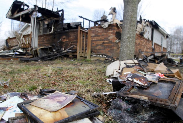 This Sunday, March 10, 2013 photo shows the charred remains of a home after a fire erupted, Saturday, March 9, 2013 in Gray, Ky, killing two adults and five children inside. (AP Photo/Lisa Norman-Hudson)
