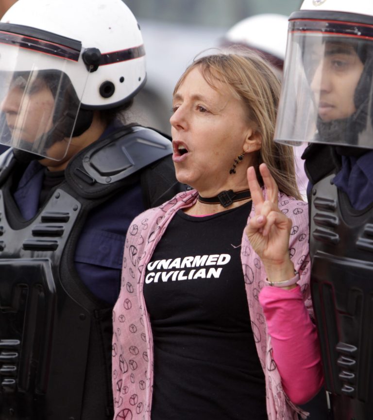 FILE - In this Friday, Feb. 17, 2012 file photo, riot police arrest U.S. activist Medea Benjamin during a protest march by Bahraini women in Qadam, Bahrain. The co-founder of U.S.-based anti-war group Code Pink says Egyptian police detained her at the airport Tuesday, March 4, 2014 when she tried to enter the country and assaulted her, fracturing her shoulder, as they handcuffed her before deporting her. Benjamin says she was detained for hours at the airport upon arrival on route to the Gaza Strip as part of an international women's delegation. (AP Photo/Hasan Jamali, File)