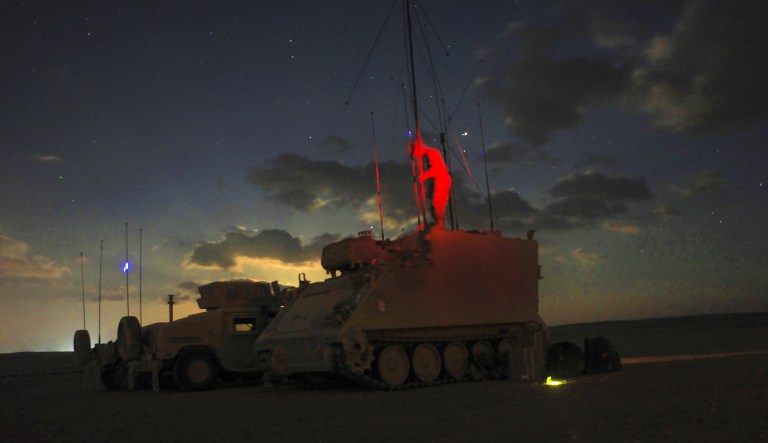 In this 2016 photo, a U.S. soldier breaks down a M113 armored personnel carrier at night. A Friday report mentions that the U.S. Army had its first live-fire exercise that involved ground robots, including an unarmed M113 carrier. (Army photo by Spc. Kevin Kim)