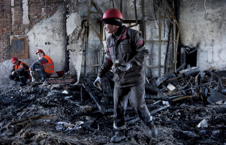 Workers of the Ukrainian company Metinvest clear away debris in a government building in the eastern Ukrainian city of Mariupol on Friday. Local patrols by steelworkers have forced pro-Russia insurgents to retreat from the government buildings they had seized in a major city in eastern Ukraine, giving residents hope that a wave of anarchy was over.
