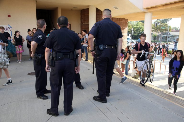South Pasadena, Calif., police officers greet students as they arrive for the first day of school at South Pasadena High School Thursday, Aug. 21, 2014. Officers were in force Thursday as students began the school year without two peers who allegedly plotted a high school massacre. (AP Photo/Nick Ut )