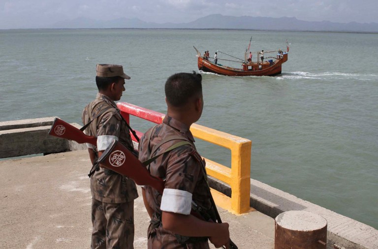   Bangladeshi Border Guard (BGB) soldiers keep watch at a wharf in Taknaf, Bangladesh, Tuesday, June 12, 2012. Bangladesh on Tuesday turned away three boats carrying 1,000 Rohingya Muslims fleeing violence in neighboring Myanmar, bringing to 1,500 the number of refugees blocked in recent days, officials said. (AP Photo/Anurup Titu)  