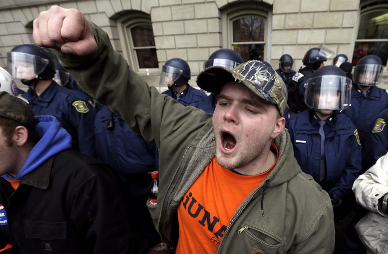   Drew Dobson, of Coleman, Mich., protests at a rally at the State Capitol in Lansing, Mich., Tuesday, Dec. 11, 2012. The crowd is protesting right-to-work legislation passed last week. Michigan could become the 24th state with a right-to-work law next week. Rules required a five-day wait before the House and Senate vote on each other's bills; lawmakers are scheduled to reconvene Tuesday and Gov. Snyder has pledged to sign the bills into law. (AP Photo/Paul Sancya)p  