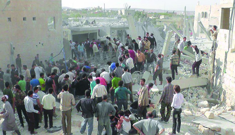 In this Wednesday, Oct. 17, 2012 photo, citizen journalism image provided by Edlib News Network, ENN, which has been authenticated based on its contents and other AP reporting, Syrian citizens gather to rescue people from under the rubble of a building that was destroyed from a Syrian force airstrike, at Kfar Nebel town, in Idlib province, northern Syria. (AP Photo/Idlib News Network ENN)
