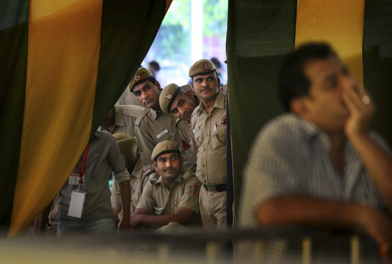 Indian policemen on duty watch election results on television at a counting station in New Delhi, India, Friday, May 16, 2014. India's main Hindu nationalist party was making early gains Friday as officials began counting votes following the country's massive national election, with the opposition looking to end the ruling Congress party's decade-long reign. The Election Commission was expected to announce the results later in the day. (AP Photo/Manish Swarup)