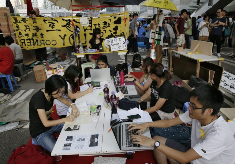 Pro-democracy students do their homework at a study area at a main road in the occupied areas in Hong Kong's Admiralty district, Saturday, Oct. 11, 2014. Students and activists demanding a greater say in choosing the city's leader have vowed to stay until the government responds, while the government has repeatedly urged protesters to withdraw from the streets and allow the city to return to normal. (AP Photo/Vincent Yu)