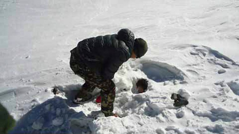In this photo provided by the Nepalese army, a Nepalese army soldier searches for avalanche victims at Thorong La pass area in Nepal, Sunday, Oct. 19, 2014. Nepalese officials closed a section of a popular Himalayan trekking route Sunday after rescuers, overwhelmed with last week's snowstorms that killed 38 hikers, had to bring to safety new climbers who set out on the same mountain trails where the blizzards struck. (AP Photo/Nepalese Army)