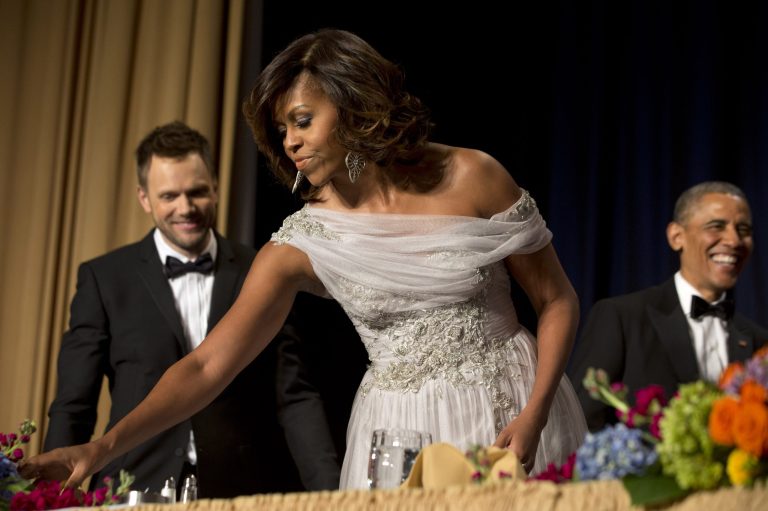 First lady Michelle Obama, center, takes her seat with Joel McHale, star of the NBC series Community, at left, and President Barack Obama, at right, during the centennial dinner of the White House Correspondents' Association (WHCA) at the Washington Hilton Hotel, Saturday, May 3, 2014, in Washington. (AP Photo/Jacquelyn Martin)