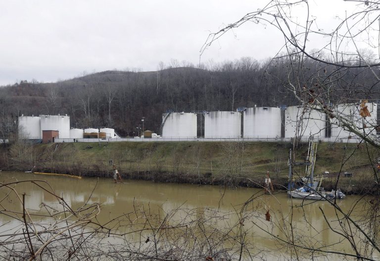 On Jan. 13, workers inspect an area outside a retaining wall around storage tanks where a chemical leaked into the Elk River at a Freedom Industries storage facility in Charleston, W.Va. (AP Photo/Steve Helber)