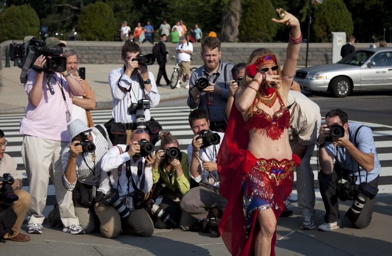News photographers photograph a group of belly dancers that came to the Supreme Court  in Washington, Thursday, June 28, 202, in favor of a form of Medicare for all people, as they waited for a landmark decision on health care.  (AP Photo/Evan Vucci)