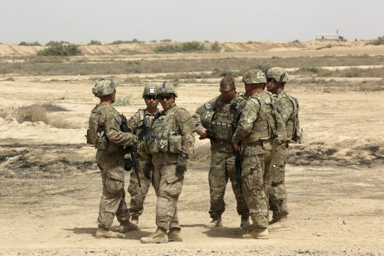 U.S. soldiers prepare to participate in a training mission with Iraqi Army soldier, right, outside Baghdad, Iraq, Wednesday, May 27, 2015. (AP Photo)