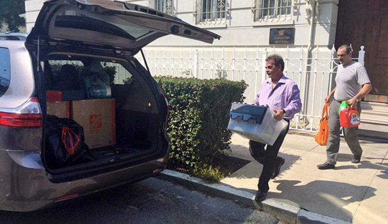 Workers carry boxes out of the Russian consulate in San Francisco as acrid, black smoke was seen pouring from a chimney at the stately building in a historic area of the city Friday, Sept. 1, 2017, a day after the Trump administration ordered its closure amid escalating tensions between the United States and Russia. The workers were hurrying to shut Russia's oldest consulate in the U.S. ahead of a Saturday deadline. (AP Photo/Garance Burke)