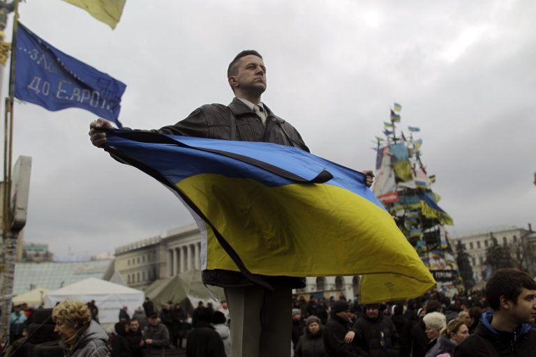 An anti-administration protester holds an Ukrainian flag in Kiev's Independence Square, the epicenter of the country's current unrest, on Tuesday. (AP Photo/Marko Drobnjakovic)