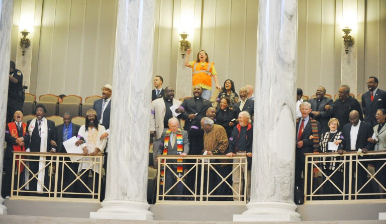 A number of people filled the Missouri Senate Gallery in Jefferson City and performed an act of civil disobedience on Tuesday, May 6, 2014. They were with the Faith Community Rally in Jefferson City to protest the senate's rejection of the expanded Medicaid coverage under the Affordable Care Act, commonly referred to as Obamacare. These were the last four who refused to leave after the deliberative body was shut down for an hour and 23 people were arrested during the protest. (AP Photo/The Jefferson City News-Tribune, Julie Smith)