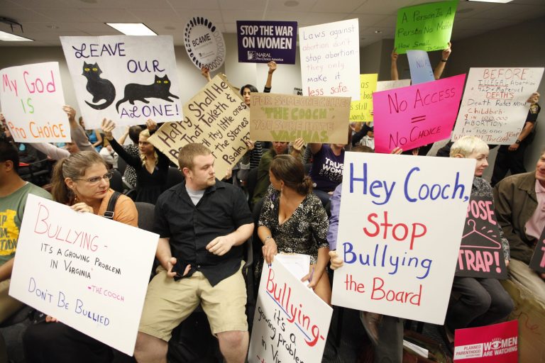 Protesters hold signs as they wait for the Virginia Board of Health meeting on abortion clinic regulations on Friday, Sept. 14. (AP Photo)