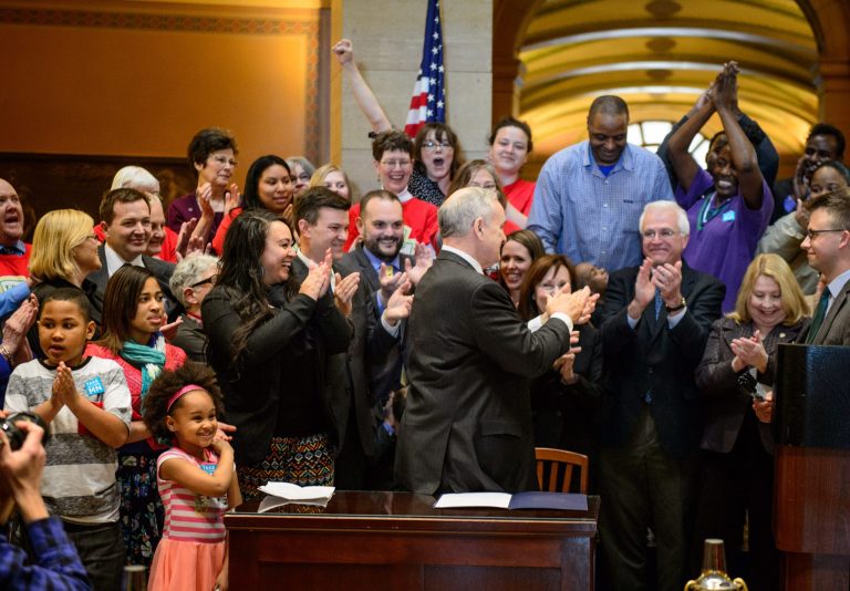 The crowd cheers after Governor Mark Dayton signed the minimum wage bill into law at a public bill signing ceremony Monday, April 14, 2014 at the Minnesota State Capitol Rotunda in St. Paul.  Minnesota goes from having one of the nation's lowest minimums to among the highest. With federal wage legislation stuck in Congress, states are rushing to fill the void.   (AP Photo/The Star Tribune, Glen Stubbe)  MANDATORY CREDIT; ST. PAUL PIONEER PRESS OUT; MAGS OUT; TWIN CITIES TV OUT