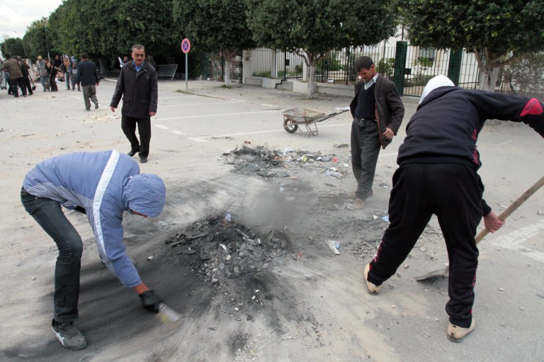   Local people clean damages in the street a day after clashes between protestors and riot police in Siliana, Tunisia, Sunday, Dec. 2, 2012. The Regional Workers Union in Siliana announced a provisional halt to the strike Sunday, hours after agreeing to a deal with the central government in Tunis, the capital of this North African nation. (AP Photo / Amine Landoulsi)  