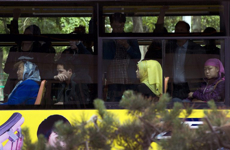 In this Friday, May 23, 2014 photo, ethnic Chinese and Uighur commuters take a public transport bus in Urumqi, China's northwestern region of Xinjiang. State media say ethnic Chinese and minorities mix easily in Urumqi, capital of the Xinjiang region. But interviews with more than two dozen residents following Thursdayâs bombing at a vegetable market that killed at least 43 people suggest a harsher reality in which the two groups regard each other across a tense gulf of misunderstanding and suspicion. Relations have deteriorated since rioting in 2009 left nearly 200 people dead. Both groups are moving out of ethnically mixed neighborhoods, making an already divided city of 3 million people even more segregated. (AP Photo/Andy Wong)
