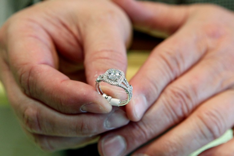 In this May 14, 2014 photo, Brad Padgett, owner of Bradley's Jewelers, shows off one of his favorite engagement rings in Jacksonville, N.C.  The answer to the question of how much to spend on an engagement ring rests in striking a balance between a ring that will dazzle your beloved without tarnishing your future financial goals together. (AP Photo/The Daily News, Maria Sestito)