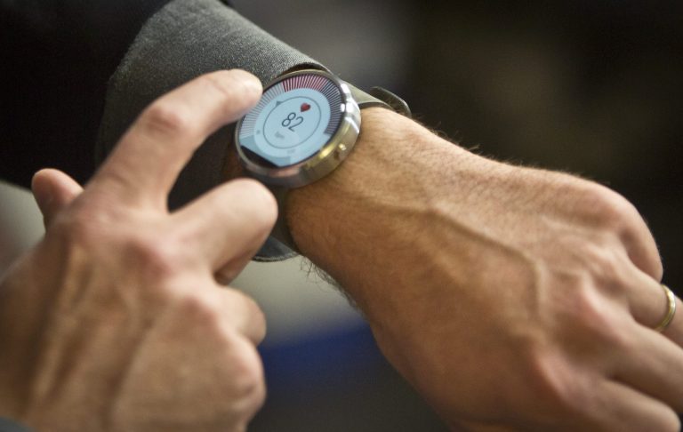 Steve Sinclair, Motorola's vice president of product management, demonstrates the new Moto 360 circular smartwatch, the company's first, during an interview, Wednesday Aug. 27, 2014 in New York.  (AP Photo/Bebeto Matthews)