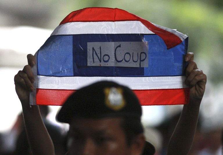 In this photo taken May 25, 2014, a protester holds a banner during an anti-coup demonstration in Bangkok, Thailand.  The last time Thailand's army seized power, in 2006, some called it 