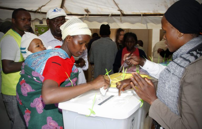 Kenyan women get ready to cast their ballots to cast their votes in Kibera's Slums, Nairobi, Kenya Monday, March 4, 2013. Kenya on Monday is holding its first presidential election since the 2007 vote which ushered in months of tribal violence that killed more than 1,000 people and displaced 600,000 from their homes. (AP Photo/Khalil Senosi)