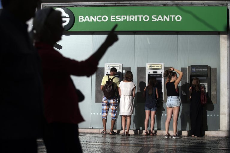 In this July 28, 2014 photo, people use ATMs at a branch of Portuguese bank Banco Espirito Santo in Lisbon. The Espirito Santo family business survived wars, dictatorship, revolution and family feuds for almost 150 years. Now, one of Europe's last banking dynasties is being stripped of its wealth and influence amid accounting irregularities, huge unreported debts, and a police investigation. (AP Photo/Francisco Seco)