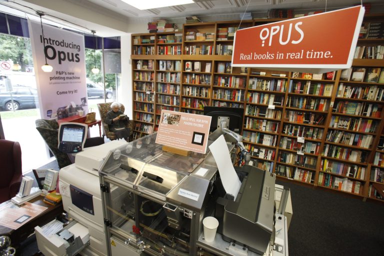   In this June 5, 2012, photo, a customer reads a book by the Espresso Book Machine, known as Opus, at Politics and Prose bookstore in Washington. Self-publishing has been made easier since the machine by On Demand Books debuted in 2006. The machine also can makes copies of out-of-print editions. The first machine was installed briefly at the World Bankâs bookstore. Through a partnership with Xerox, the company now has machines in about 70 bookstores and libraries across the world including London; Tokyo; Amsterdam; Abu Dhabi, United Arab Emirates; Melbourne, Australia; and Alexandria, Egypt. (AP Photo/Jacquelyn Martin)  