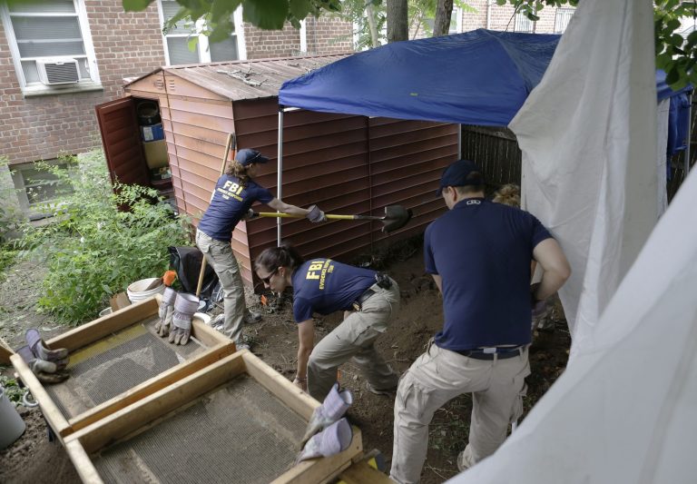 FILE - In this June 18, 2013 file photo, FBI agents search the backyard of a house once occupied by James 