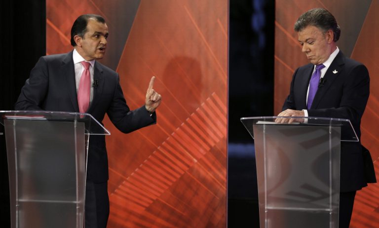 FILE - In this June 9, 2014 file photo, presidential candidate Oscar Ivan Zuluaga, left, points as he faces Colombia's President Juan Manuel Santos during a televised debate in Bogota, Colombia. Colombia's nastiest presidential campaign in years has focused largely on a single issue:  Santos' prescription for ending the nation's half-century-old guerrilla conflict. Colombia will hold a presidential runoff election on Sunday, June 15. (AP Photo/Fernando Vergara, File)