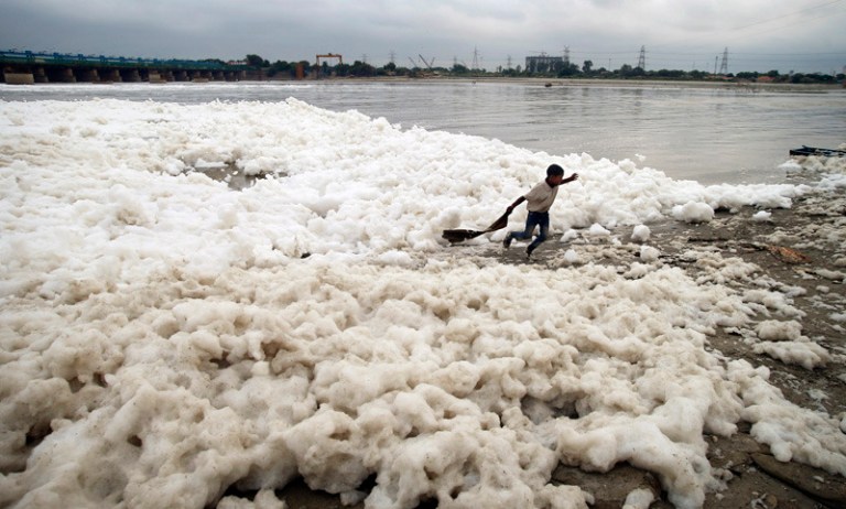 A young boy runs amidst polluted water of the river Yamuna in New Delhi, India, Friday, Oct. 4, 2013. (AP Photo/Saurabh Das)