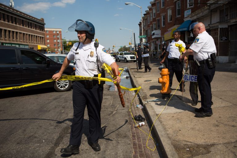 An officer takes down police tape after an incident on North Ave., near the site of recent riots and only several blocks away from where Freddie Gray was arrested last month, May 4, 2015 in Baltimore, Md. (Getty Image)