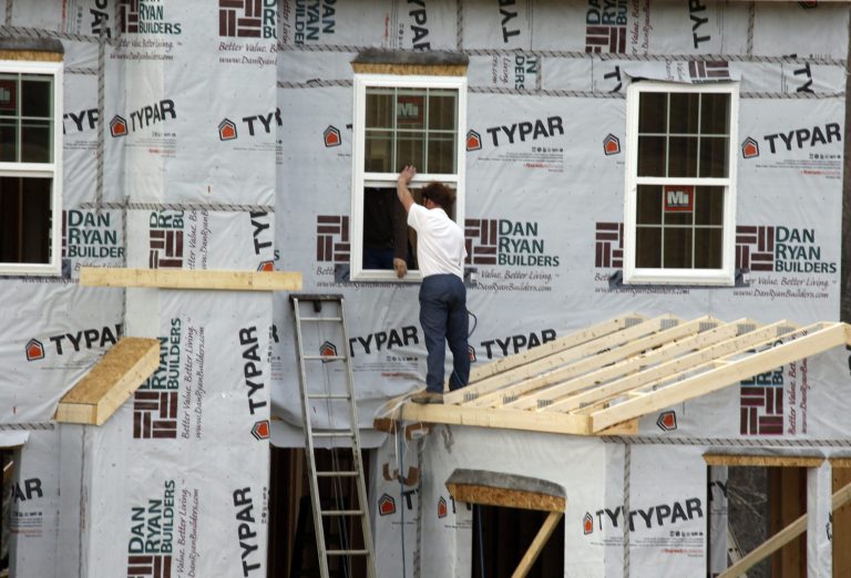 In this photo made on Friday, March 28, 2014, workers continue construction on a housing plan in Zelienople, Pa.