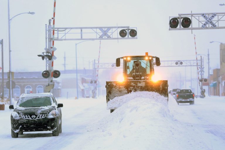 A City of Hutchison, Kan., front end loader clears snow from intersections on S. Main St. Tuesday, Feb. 4, 2014. The winter storm dumped more than 10 inches of snow on the city from late Monday to late Tuesday. (AP Photo/The Hutchinson News, Travis Morisse)