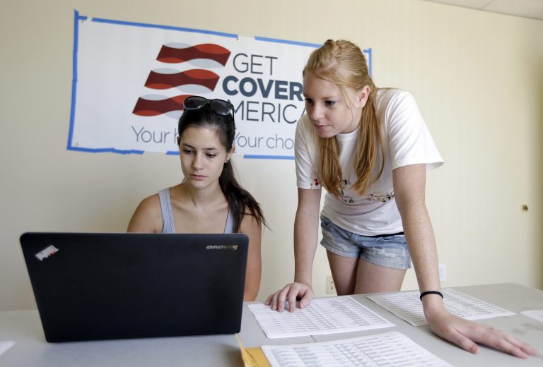 Ashley Hentze, left, of Lakeland, Fla., gets help signing up for healthcare from Kristen Nash, a volunteer with Enroll America, a private, non-profit organization running a grassroots campaign to encourage people to sign up for healthcare, Tuesday, Oct. 1, 2013, Tampa, Fla. (AP Photo/Chris O'Meara)