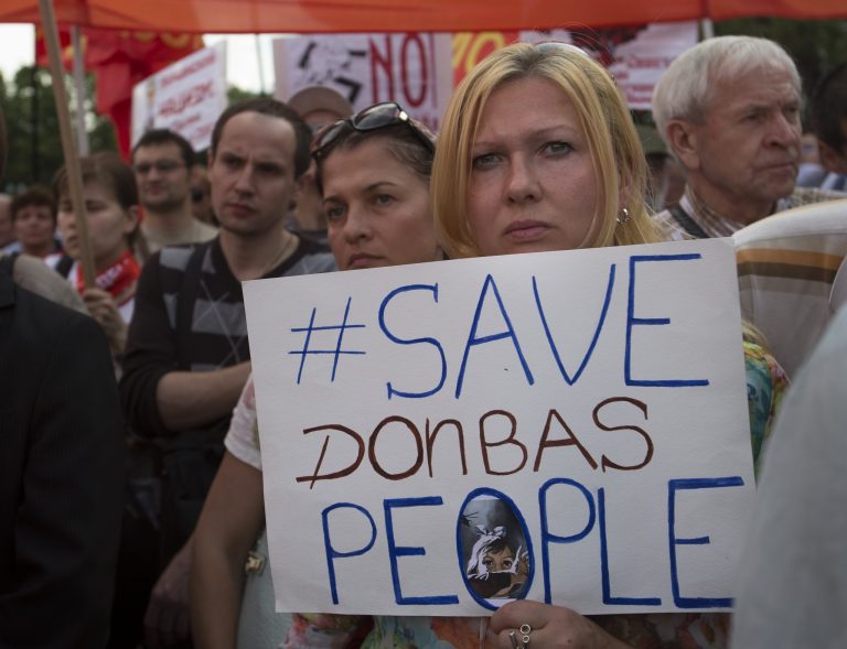 A woman holds a poster reading  