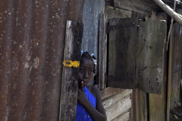 FILE - In this Sept. 30, 2013 file photo, Haitian Maria Julia Deguis looks out from her home in Los Jovillos village, in the Monte Plata province of the Dominican Republic. A law passed by Dominican Republic legislators Wednesday, May 21, 2014, creates a path to citizenship for the children and grandchildren of tens of thousands of migrants who came from neighboring Haiti to work. It follows an international outcry over a court ruling that left many essentially stateless. (AP Photo/Manuel Diaz, File)