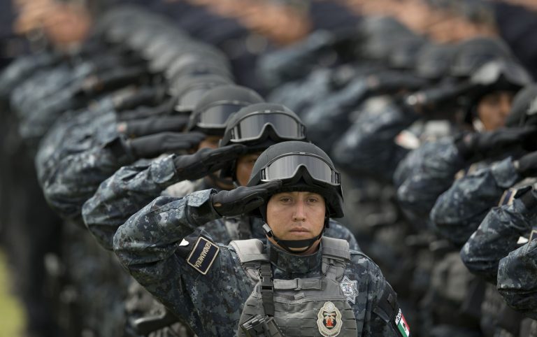 FILE - In this Aug. 22, 2014, file photo, officers belonging to Mexico's newest police force, known as the gendarmerie, salute during the launching ceremony for the new force at the Federal Police headquarters in Mexico City. Officials said Tuesday Aug. 27, 2014, that the first assignment for members of the new police force is Valle de Bravo, a chic resort town near Mexico City that has seen a recent spate of kidnappings. (AP Photo/Eduardo Verdugo, File)
