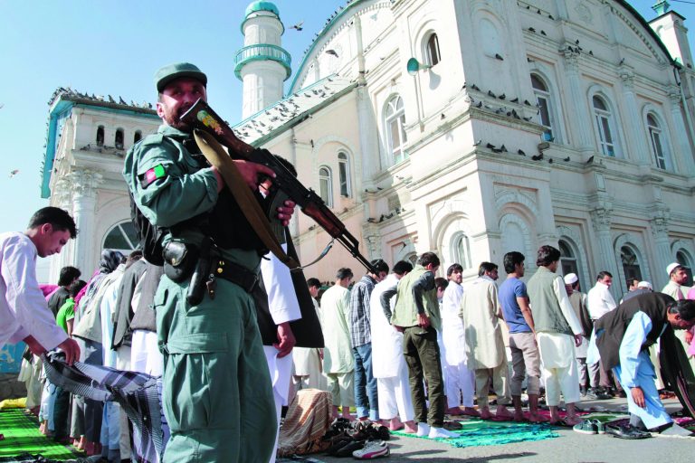 An Afghan policeman stands guard outside Shah-e- Dushamshera's mosque where Afghans offer the Eid al-Fitr's prayers that marks the end of holy fasting month of Ramadan in Kabul, Afghanistan, Sunday, Aug. 19, 2012. (AP Photo/Musadeq Sadeq)