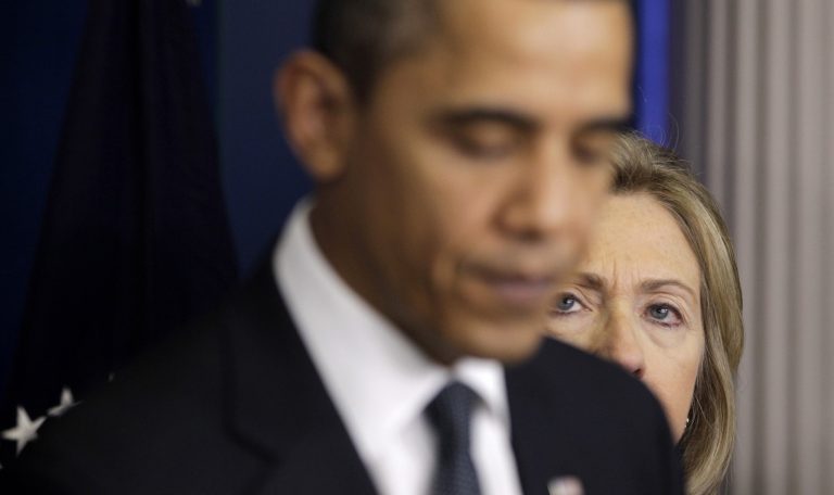 Secretary of State Hillary Rodham Clinton peers toward President Barack Obama as he speaks Thursday, Dec. 16, 2010, at the White House. (AP Photo/Charles Dharapak)