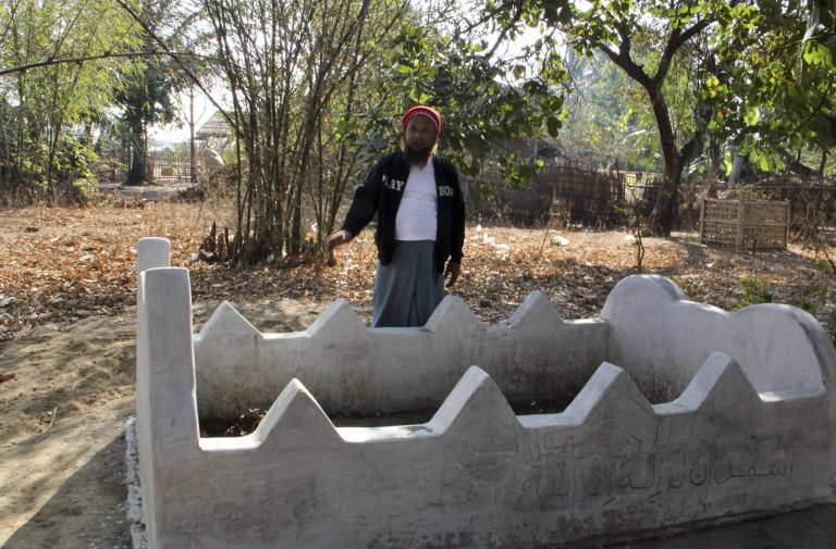 In this Feb. 27, 2014 photo, Mohamad Frukan stands next to the grave of his wife Noor Jahan, an ethnic Rohingya who died due to kidney disease,  in The' Chaung village, north of Sittwe, Rakhine state, Myanmar. (AP Photo/Pyae Phyo Thant Zin)