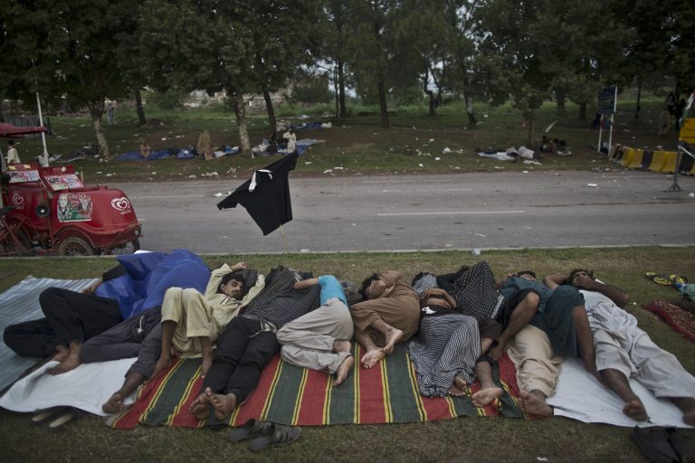 Pakistani protestors sleep on a street median in front of the Parliament building, during weeklong protests from the eastern city of Lahore to the gates of parliament calling for Prime Minister Nawaz Sharif's ouster over alleged voting fraud, in Islamabad, Pakistan, Friday, Aug. 22, 2014. They swarmed into the capital in their thousands, protesters calling for the prime minister's resignation and the dissolution of parliament. The week-long protests in the capital and around the parliament building have been loud and boisterous but peaceful. But despite their color, there is the other side to the demonstrations _ the increased demand for food, water and toilets to accommodate the thousands of people who turned out to support cricketer-turned-politician Imran Khan and popular cleric Tahir-ul-Qadri. (AP Photo/Muhammed Muheisen)