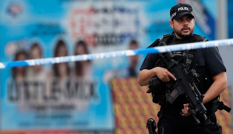 Armed police officers patrol a police cordon near the Manchester Arena in Manchester, Wednesday, May 24, 2017. Britons will find armed troops at vital locations Wednesday after the official threat level was raised to its highest point following a suicide bombing that killed more than 20, as new details emerged about the bomber.(AP Photo/Kirsty Wigglesworth)