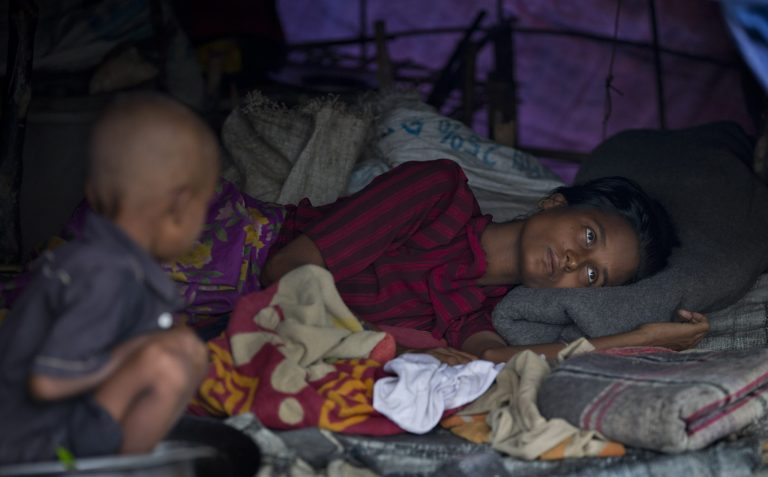 In this Sept. 17, 2013 photo, a sick Muslim woman, who become displaced following 2012 sectarian violence, rests in a camp for displaced at Nga Chaung Refugee Camp in Pauktaw, Rakhine state, Myanmar.  Severe shortages of food, water and medical care for Rohingya Muslims in western Myanmar are part of a long history of persecution against the religious minority that could amount to 