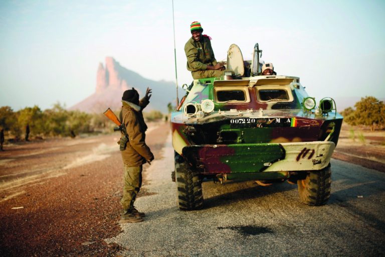 A convoy of Malian troops makes a stop to test some of their weapons near Hambori, northern Mali, on the road to Gao, Monday Feb. 4, 2013. French troops launched airstrikes on Islamic militant training camps and arms depots around Kidal and Tessalit in Mali's far north, defense officials said Sunday, as the first supply convoy of food, fuel and parts to eastern Mali headed across the country. (AP Photo/Jerome Delay)