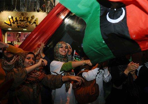 Women wave a pre-Gadhafi flag as they gather to celebrate the death of deposed Libyan dictator Moammar Gadhafi in Cairo, Egypt, Thursday, Oct. 20, 2011. Moammar Gadhafi, Libya's dictator for 42 years until he was ousted in an uprising-turned-civil war, was killed Thursday as revolutionary fighters overwhelmed his hometown of Sirte and captured the last major bastion of resistance two months after his regime fell. (AP Photo)