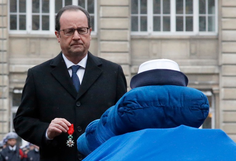 French President Francois Hollande holds a medal in front of the coffin of Police officer Clarissa Jean-Philippe during a ceremony to pay tribute to the three police officers killed in the attacks, in Paris, France, Tuesday. (AP/Francois Mori)