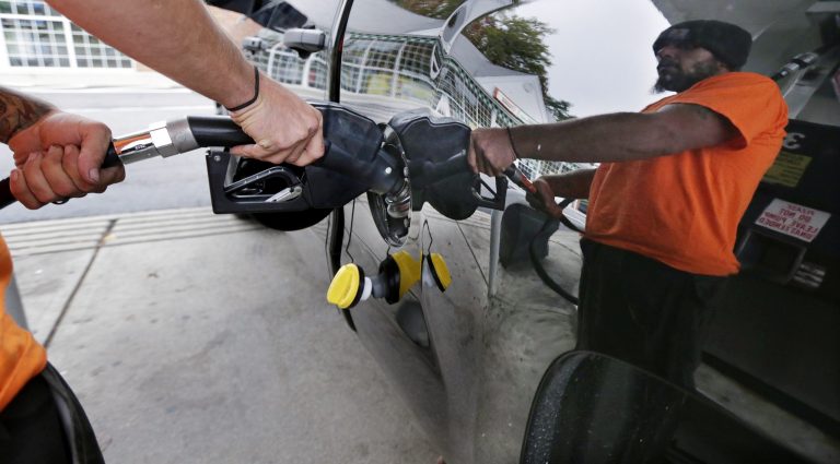 In this Sept. 30, 2014, photo, Dana Ripley, of Winthrop, Massachusetts, fills the gas tank of his truck at a service station in Andover, Massachusetts. 