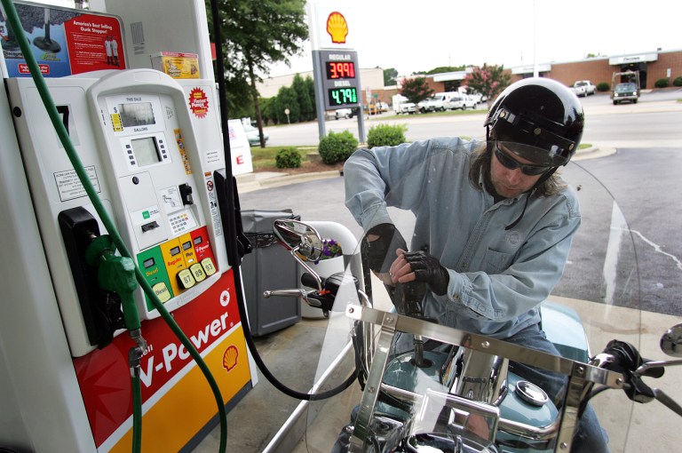 Mark McCormick fills his motorcycle at a gas station in Raleigh, N.C., which dropped the tax on a gallon of gasoline to 35 cents per gallon on Jan. 1. (Bloomberg Photos)